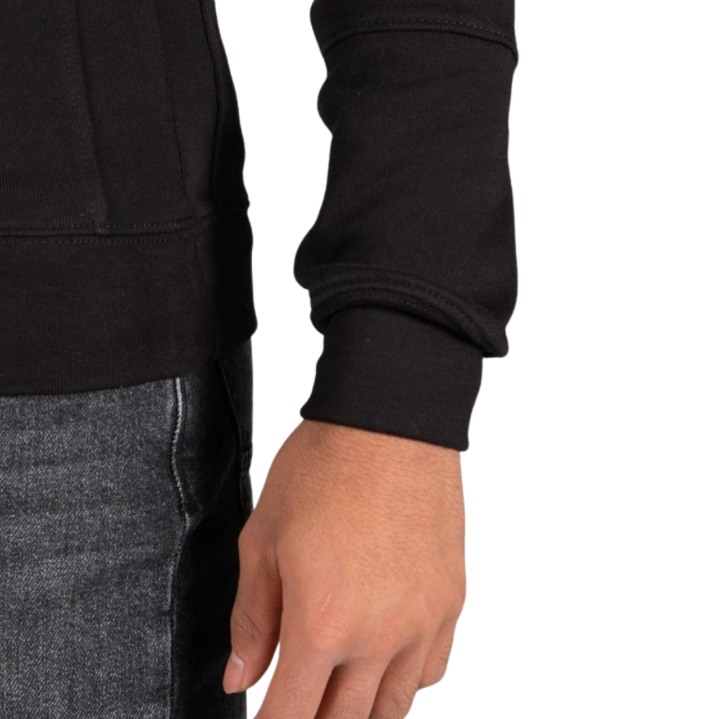 Model wearing the black Wrong Friends Leon crewneck, with branded sleeve patch.