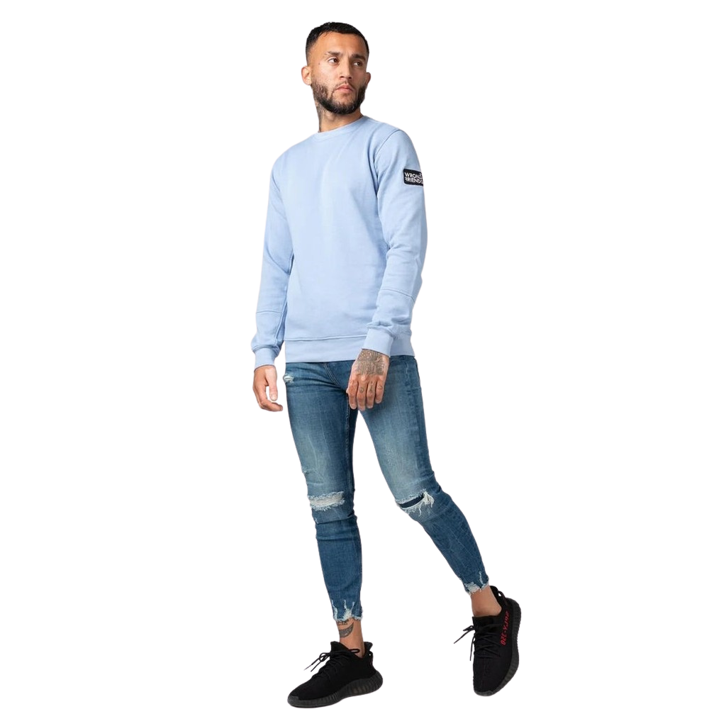 Model wearing the light blue Wrong Friends Leon crewneck, with branded sleeve patch.