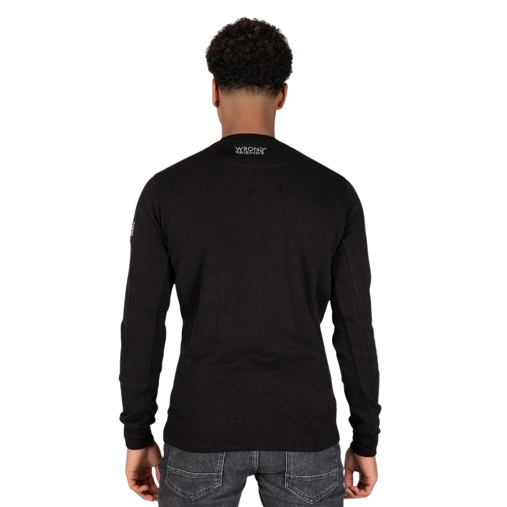 Model wearing the black Wrong Friends Leon crewneck, with the branded sleeve patch