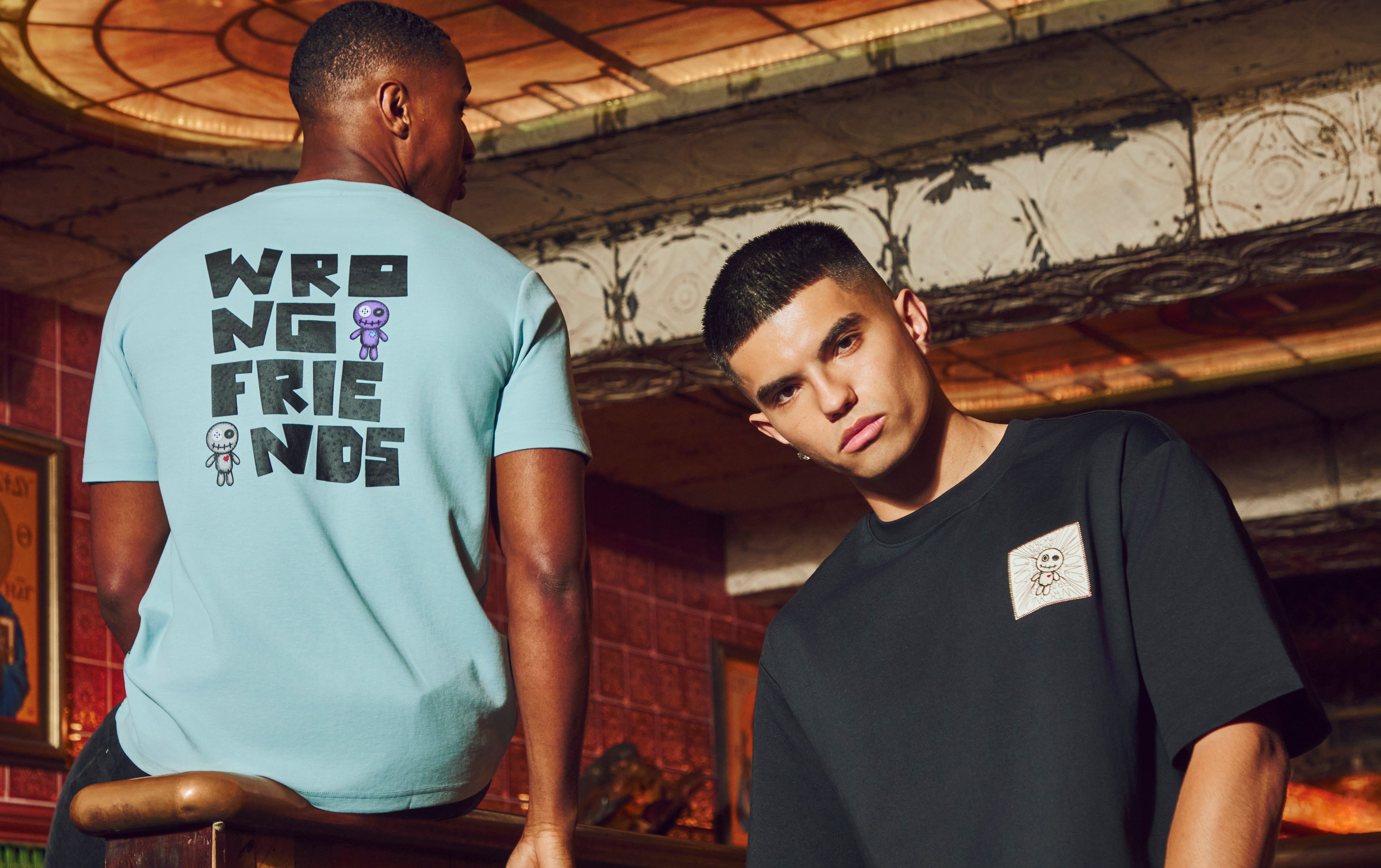 Models wearing the light blue and black Wrong Friends ONTARIO and RIO-BRAVO T-shirt with a typical Wrong Friends front/back logo graphic.